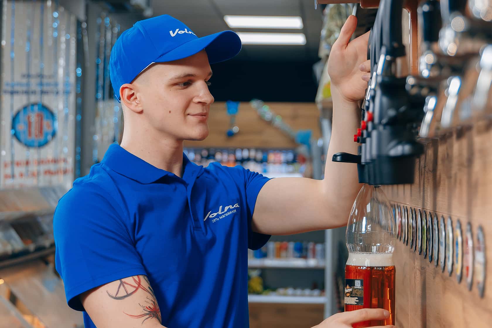 A salesperson in the blue Volna uniform by the draft beer taps