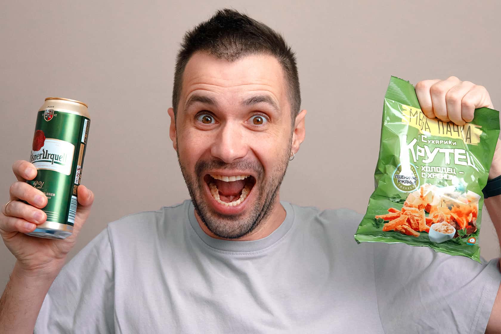 A smiling man with a can of a drink and a pack of snacks: Volna advertising shoot