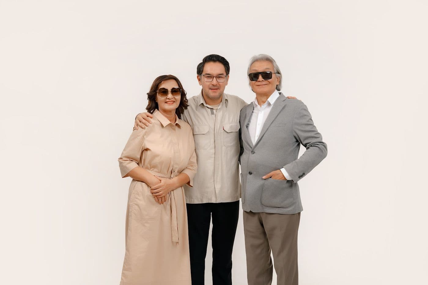 Three people in sunglasses on a light studio background