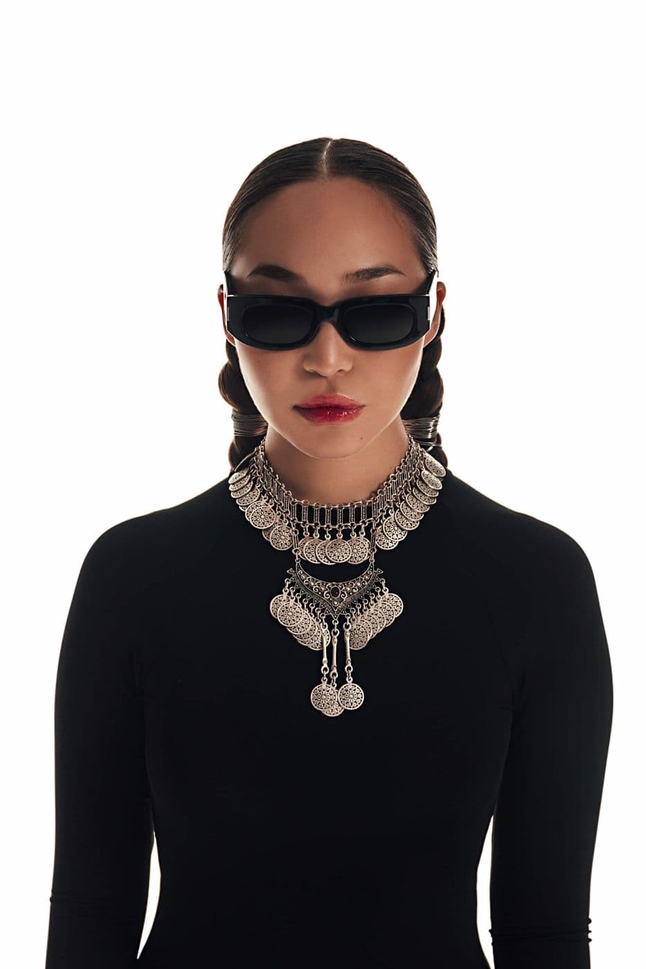 A girl in black glasses and a massive silver necklace